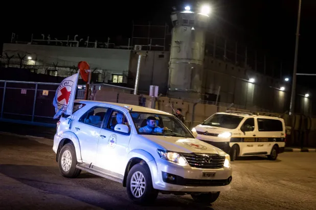 جنگ بندی کے معاہدے کے تحت فلسطینی قیدیوں کی رہائی کے دوران عوفر فوجی جیل کے باہر ریڈ کراس کی گاڑی (اے ایف پی)