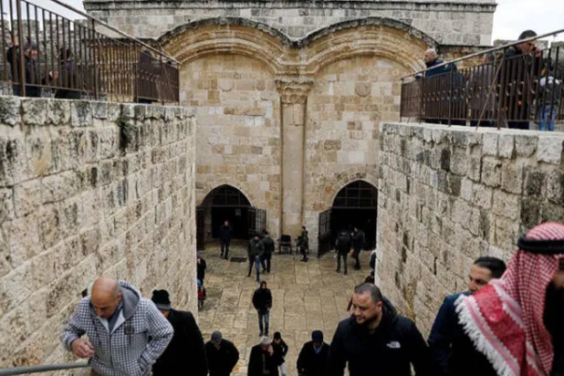 فلسطينيون يدخلون عبر البوابة الذهبية إلى المسجد الأقصى للصلاة (رويترز)