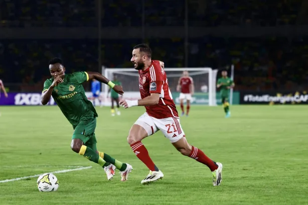 علي معلول يتقدم بالكرة وسط مضايقة تنزانية (النادي الأهلي المصري)