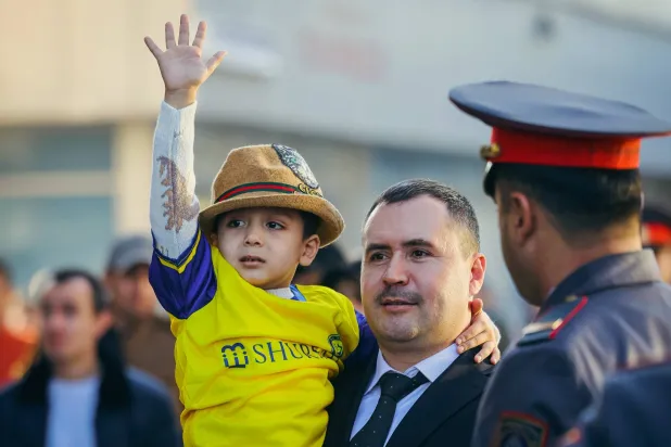 طفل طاجيكي يرتدي قميص النصر بصحبة والده (نادي النصر)