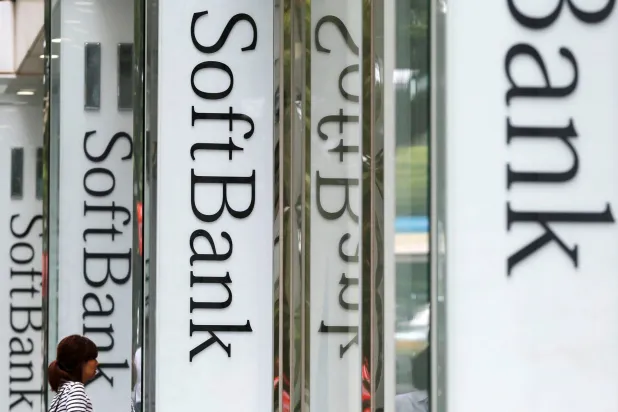 امرأة تهم بالدخول إلى فرع «سوفت بنك» في طوكيو (رويترز)