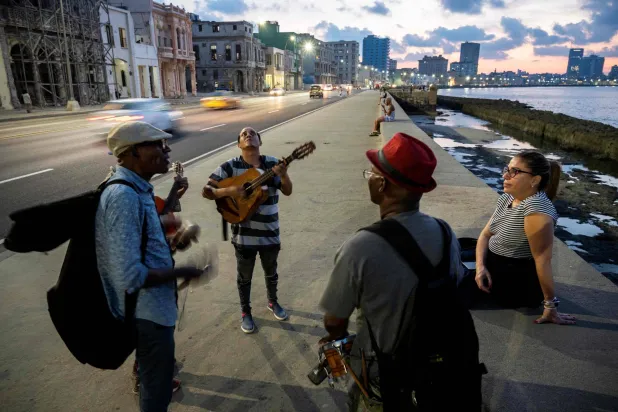 كوبيون يغنون بوليرو في أحد شوارع هافانا (أ.ف.ب)