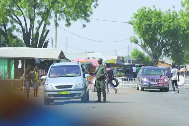 ضابط أمن يتفاعل مع سائق عند حدود بوركينا فاسو مع غانا في إطار عمليات مكافحة الإرهاب في منطقة الساحل في 6 ديسمبر 2022 (أ.ف.ب)