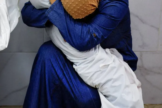 فلسطينية تحتضن جثمان ابنة أختها بمستشفى ناصر في خان يونس جنوب قطاع غزة (رويترز)