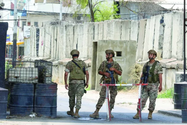 لبنانی فوجی گزشتہ موسم گرما میں دھڑوں کے درمیان جھڑپوں کے دوران "عین الحلوہ" کیمپ کے ایک داخلی راستے پر کھڑے ہیں (اے ایف پی)