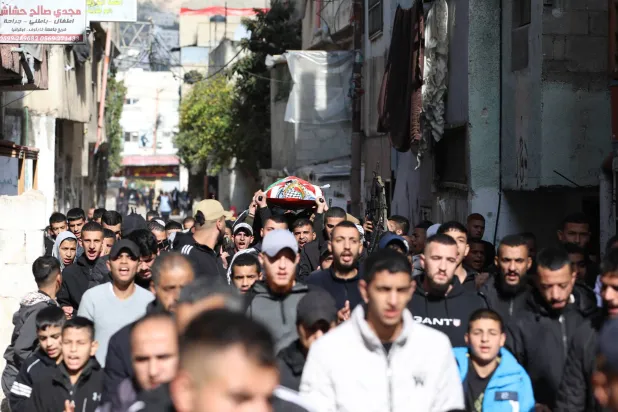 مشيعون يحملون جثمان قتيل نتيجة الاشتباكات قرب مدينة نابلس بالضفة الغربية (إ.ب.أ)