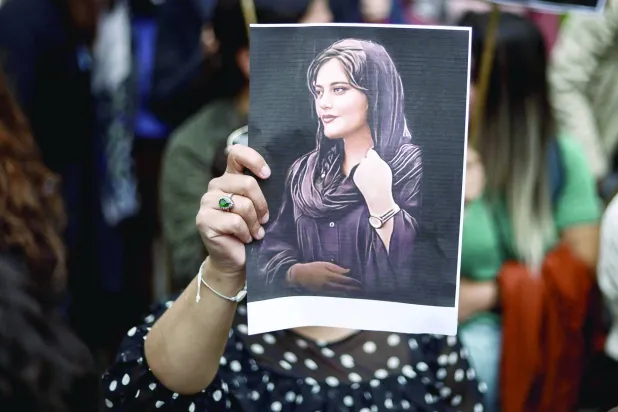 متظاهرة تحمل صورة مهسا أميني خلال مظاهرة أمام السفارة الإيرانية في بروكسل 23 سبتمبر 2022 (أ.ف.ب)