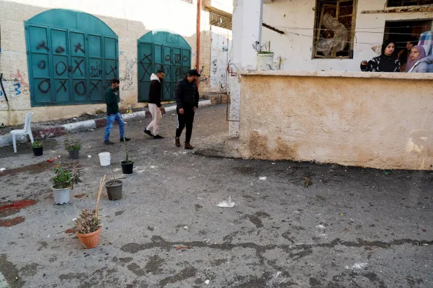 الأهالي يتفقدون الموقع الذي قُتل فيه 4 فلسطينيين بطائرة مسيرة في جنين الثلاثاء (رويترز)