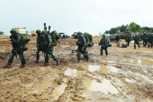 اسرائیلی فوجی کل غزہ کی پٹی کے ساتھ سرحد کے قریب ایک ٹھکانے کی جانب جاتے ہوئے (ای پی اے)