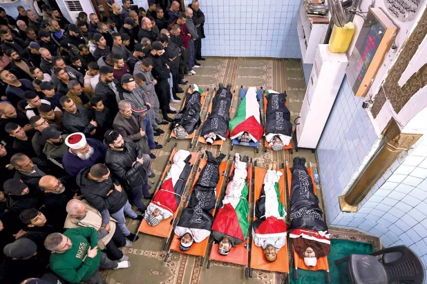 مغربی کنارے کے جنین کیمپ میں گذشتہ روز اسرائیلی حملے میں ہلاک ہونے والے فلسطینیوں کی نماز جنازہ کی ادائیگی (اے ایف پی)