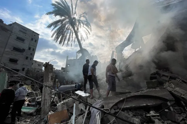 Palestinians inspect the site of an Israeli raid on a house in Rafah, south of the Gaza Strip, on Thursday. (Reuters)