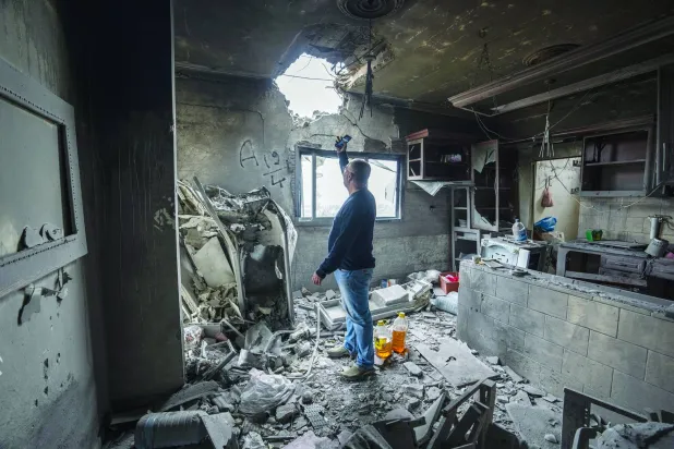 Hussein Fawaz inspects damages to his family house that was hit by Israeli shelling in the Kfar Kila border village with Israel in south Lebanon, Saturday, Nov. 25, 2023. (AP Photo/Hassan Ammar)
