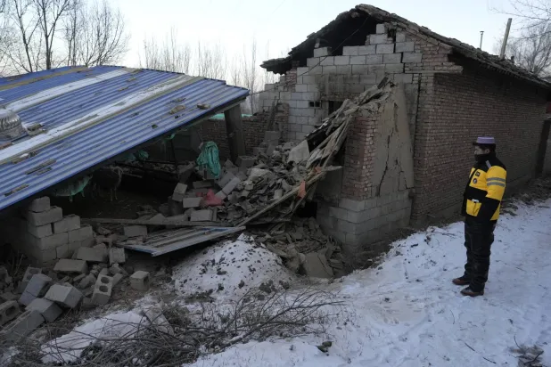 گانسو صوبے کے یانغوا گاؤں کا ایک رہائشی شخص زلزلے کے بعد کا منظر دیکھ رہا ہے (اے پی)