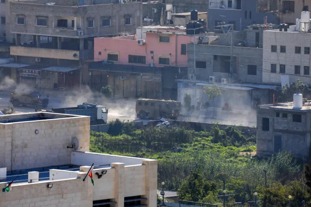 مغربی کنارے میں "نور شمس" کیمپ پر حملے کے بعد اسرائیلی فوجی گاڑیاں پیچھے ہٹ رہی ہیں (اے ایف پی)