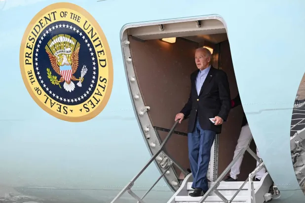 الرئيس الأميركي جو بايدن ينزل من الطائرة الرئاسية بمطار سانت كروا في جزر العذراء الأميركية اليوم لقضاء عطلة رأس السنة الجديدة (أ.ف.ب)