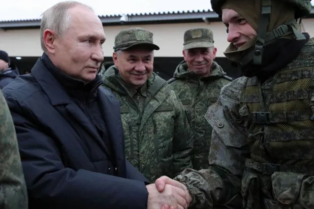Putin and his Defense Minister Sergei Shoigu visiting to a military training camp in October (AFP)