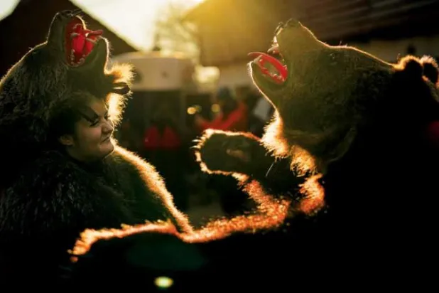 استعراض للأشخاص الذين يرتدون أزياء من فرو الدب في رومانيا (أ.ب)