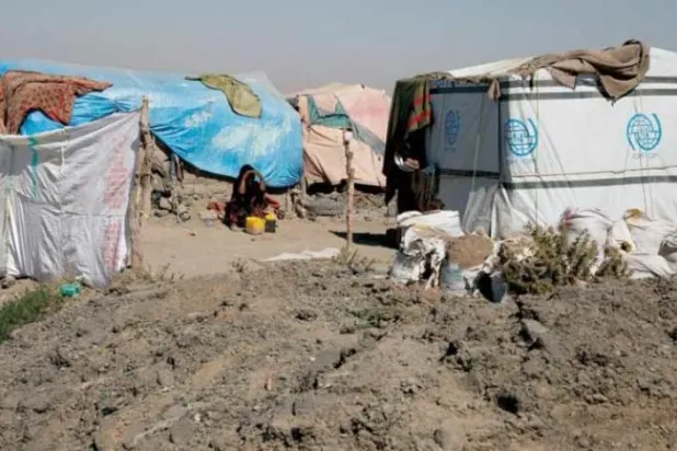 Sana kırsalında yerlerinden edilmiş insanlara yönelik bir kampta geçici bir barınakta oturan Yemenli bir kadın (EPA)