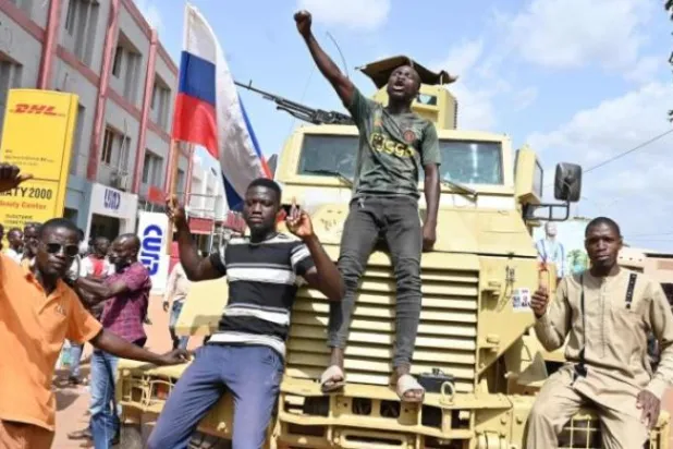 متظاهرون ضد فرنسا في واغادوغو ببوركينا فاسو يرفعون العلم الروسي (أ.ف.ب)