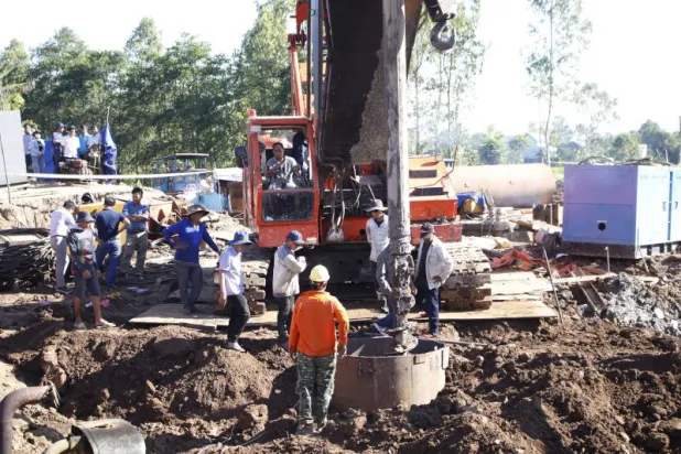 مهندسون وعمال في موقع سقوط الطفل بورشة بناء جسر في جنوب فيتنام (إ.ب.أ)