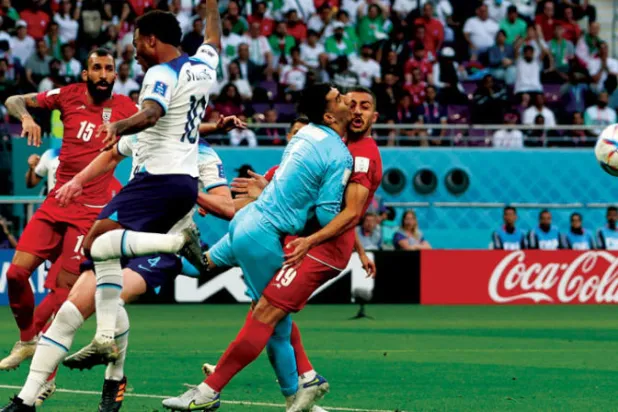 حارس مرمى إيران علي رضا بيرانفاند (يمين) في تصادم مؤلم مع زميله في الفريق ماجد حسيني (رويترز)