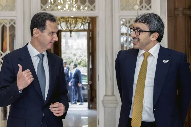 In this photo released by the official Syrian state news agency SANA, Syrian President Bashar al-Assad, left, speaks with United Arab Emirates Foreign Minister Sheikh Abdullah bin Zayed in Damascus, Syria, Wednesday, Jan. 4, 2023. (SANA via AP)