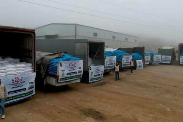 İdlib'de Filistin'den yerinden edilmiş Suriyelilere yardım yüklü tırlar (AFP)