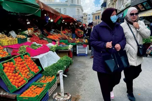نساء يسرن في سوق بتونس العاصمة (رويترز)