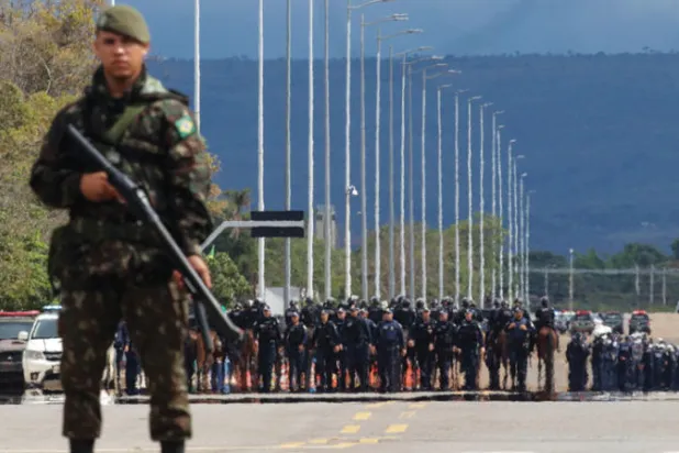 جنود يراقبون انسحاب مؤيدي بولسونارو من مقر تجمعهم الرئيسي قرب ثكنة للجيش في برازيليا أمس (أ.ب)