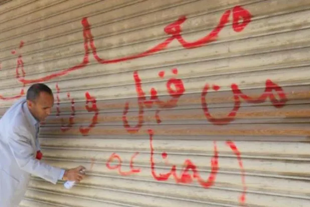 عنصر حوثي يغلق متجراً في صنعاء (إعلام حوثي)