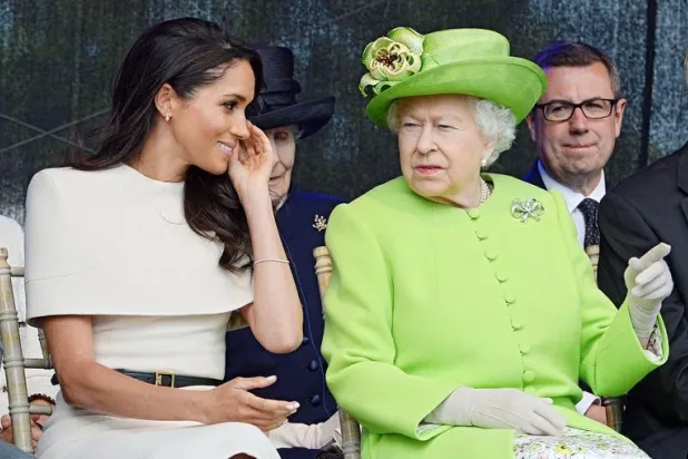 الملكة البريطانية إليزابيث تجلس إلى جانب ميغان زوجة الأمير هاري (رويترز)