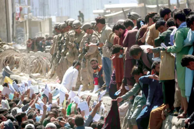 أفغان يحاولون عرض مستنداتهم على القوات الأجنبية في مطار كابل خلال عملية الانسحاب من أفغانستان 26 أغسطس 2021 (إ.ب.أ)