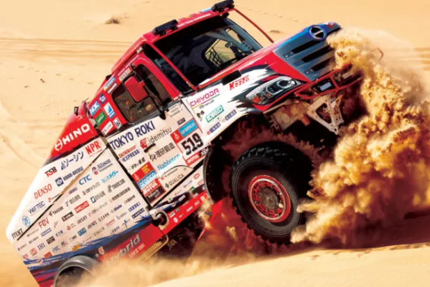 شاحنه ترتقي إحدى الهضاب الرملية خلال منافسات أمس (إ.ب.أ)