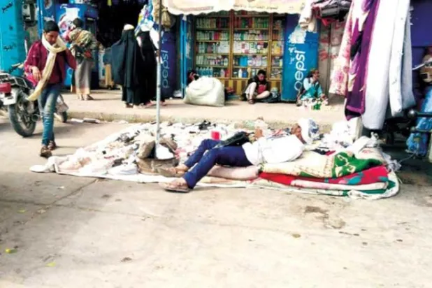 أحد باعة الأرصفة في مدينة إب اليمنية يفترش الأرض منتظراً مرور زبائنه (الشرق الأوسط)