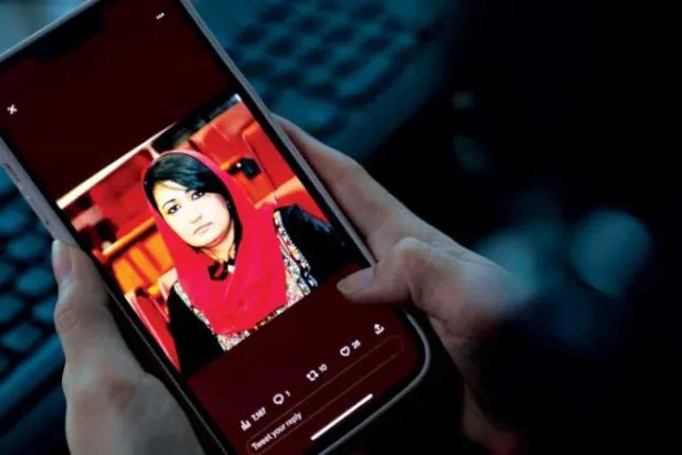امرأة تنظر إلى صورة النائبة الأفغانية السابقة مرسال نبي زاده على هاتفها الجوال التي قُتلت برصاص مسلحين الليلة الماضية في منزلها بكابل (أ.ف.ب)