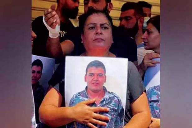 والدة ويليام نون تحمل صورة ابنها جوالذي قضى في الانفجار (الوكالة المركزية)