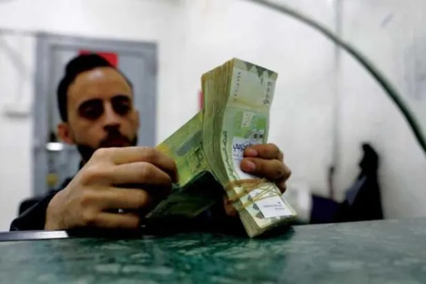 Sana’daki bir döviz bürosundaki bir işçi, Yemen banknotlarını sayıyor (EPA)