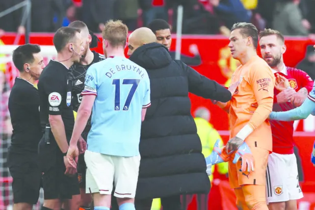 غوارديولا ولاعبو سيتي يعترضون على احتساب الحكم ستيوارت لهدف يونايتد الأول (رويترز)