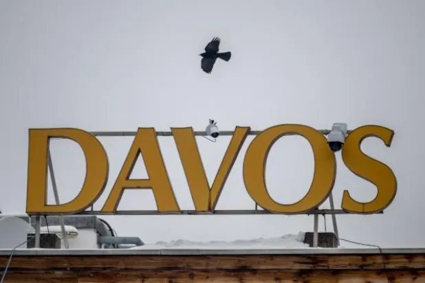 طائر يحلّق فوق شعار «دافوس» على الفندق المخصص للمؤتمر في سويسرا (أ.ف.ب)