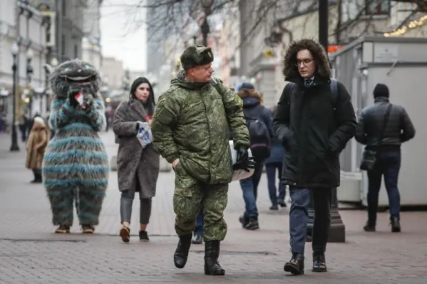 جندي روسي يسير في شارع بوسط موسكو اليوم (إ.ب.أ)