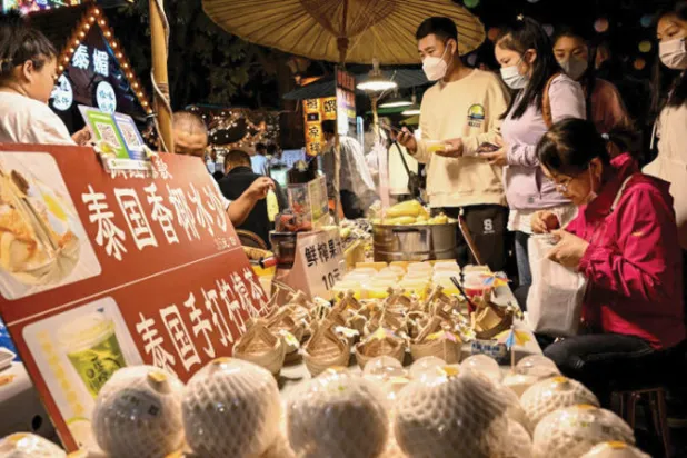 صينيون يشاهدون مصنوعات يدوية في مقاطعة يونان الجنوبية خلال موسم الاعياد (أ.ف.ب)