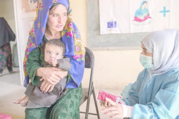 أفغانية مع طفلها في مركز لمنظمة «أنقذوا الأطفال» أرشيفية (أ. ب)