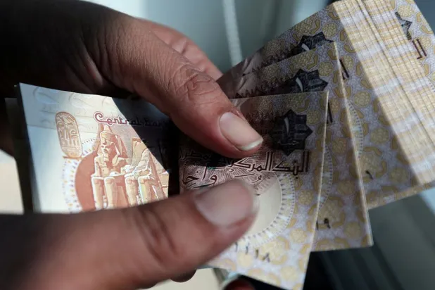 A man counts Egyptian pounds outside a bank in Cairo, Egypt October 24, 2016. (Reuters)