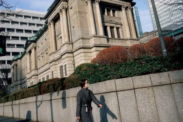 أحد المارة بجوار مقر بنك اليابان في طوكيو، اليابان (إ.ب.أ)
