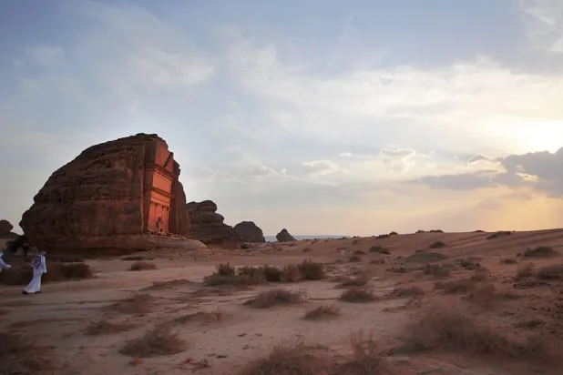 Saudi men walking near a carved rose-coloured sandstone
mountain in the Nabataean archaeological site of al-Hijr near the
northwestern town of AlUla, Saudi Arabia, on Sept. 30, 2012. (FAYEZ
NURELDINE/AFP/GettyImages)