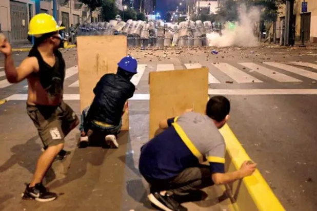 خلال المواجهات بين المتظاهرين ورجال الأمن في ليما أول من أمس (أ.ف.ب)