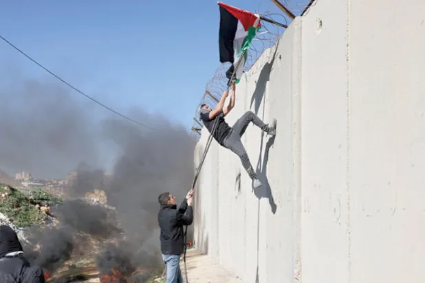 متظاهرون فلسطينيون قرب قلنديا بالضفة احتجاجاً على خطط إسرائيلية لتوسيع مستوطنة «عطروت» (أ.ف.ب)