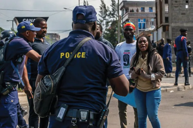 الشرطة الكونغولية تتحدث إلى متظاهرين يطالبون السلطات بفرض انسحاب متفق عليه لمتمردي حركة «23 مارس» من أراضي غوما بإقليم شمال كيفو بجمهورية الكونغو الديمقراطية (رويترز)