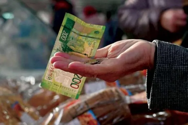 روسي يشتري مخبوزات في سوق مدينة أومسك بإقليم سيبيريا الشمالي (رويترز)