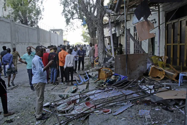 People gather outside their destroyed shops after a suicide bomber detonated at the Banadir regional administration in Mogadishu, Sunday, Jan.22, 2023. (AP)